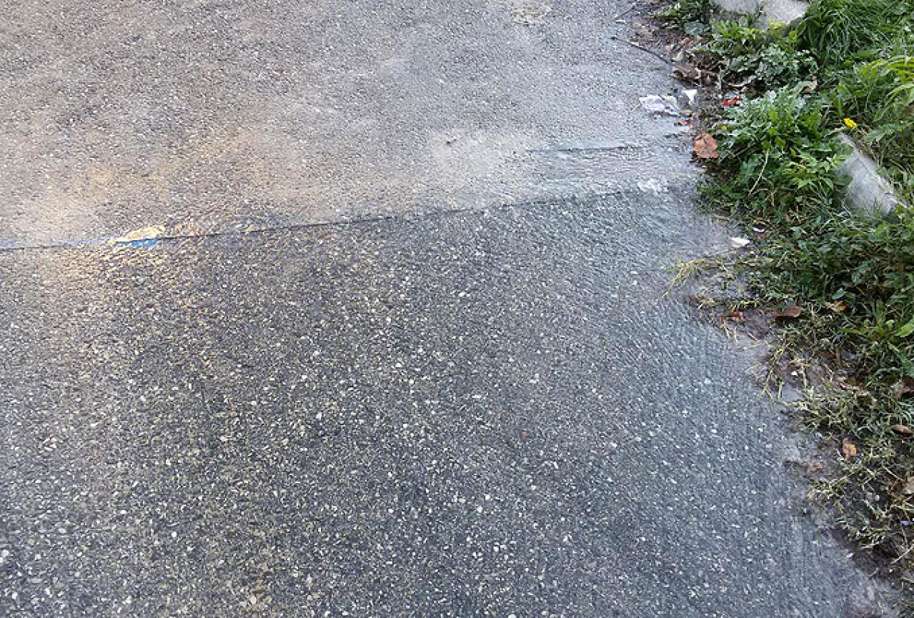 Skupa s asfaltom prerezana i vodovodna cijev