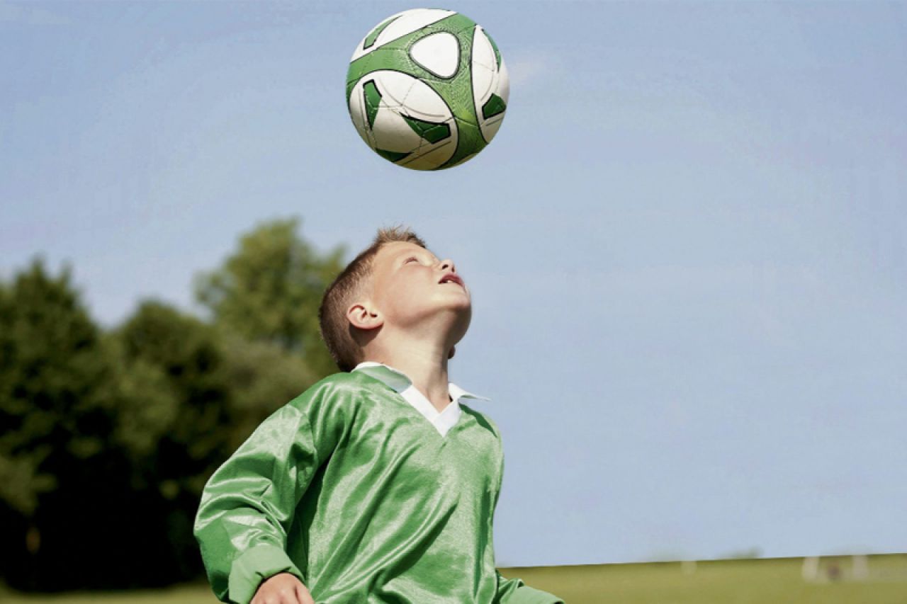 Удар мячом ребенку. Мяч в голову. Футболист с мячом на голове. Удар мяча. Дети играют в футбол.