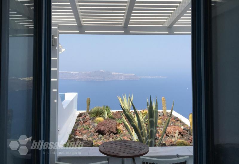 Pogled iz hotelske sobe na vulkansko kamenje u privatnom vrtu i vulkanski otok u daljini - Santorini: Mjesto plavih i bijelih krovova i najljepšeg zalaska sunca na svijetu