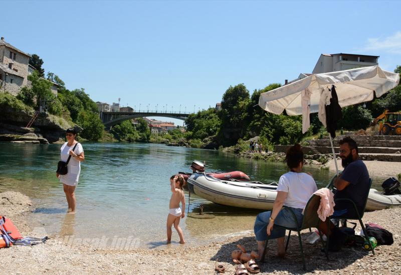 Prvog ljetnog dana turisti u Mostaru traže osvježenje u Neretvi - Prvog ljetnog dana turisti u Mostaru traže osvježenje u Neretvi
