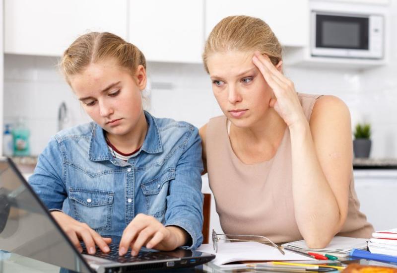 Stroga majka gleda u kćerin laptop - 10 znakova da ste strogi roditelj i kako to utječe na dijete