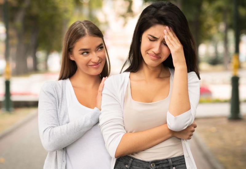 Neiskrena žena se pretvara da tješi prijateljicu - 10 znakova da je netko ljubomoran na Vas i kako reagirati