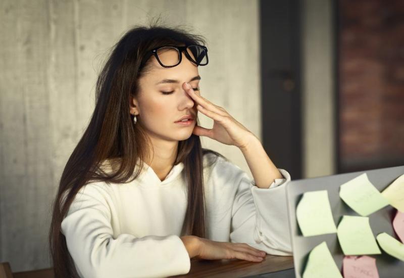 Pospana žena za radnim stolom - 10 navika koje izazivaju stres i kako ih se riješiti 