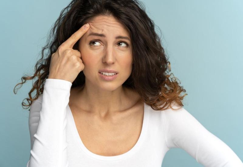 Žena dodiruje lice - 10 grešaka u govoru tijela zbog kojih djelujete slabo