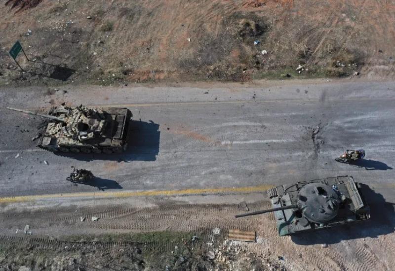 Sirijski borci voze se na motociklima pored napuštenih vozila sirijske vojske na cesti u predgrađu Hame - Turska prijeti Kurdima da će vojskom upasti u Siriju